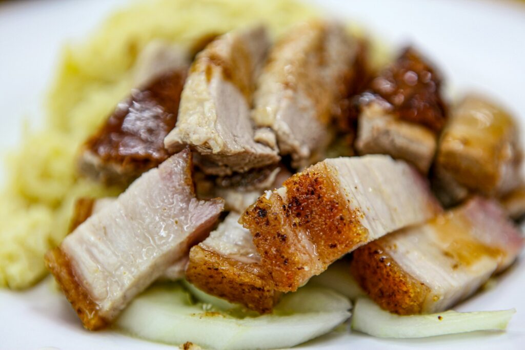 Crispy roasted pork belly served with noodles and cucumber