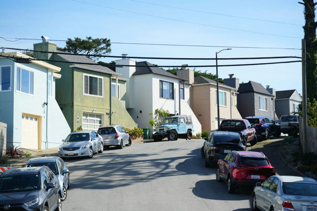 Cars parked on a residential street with houses.