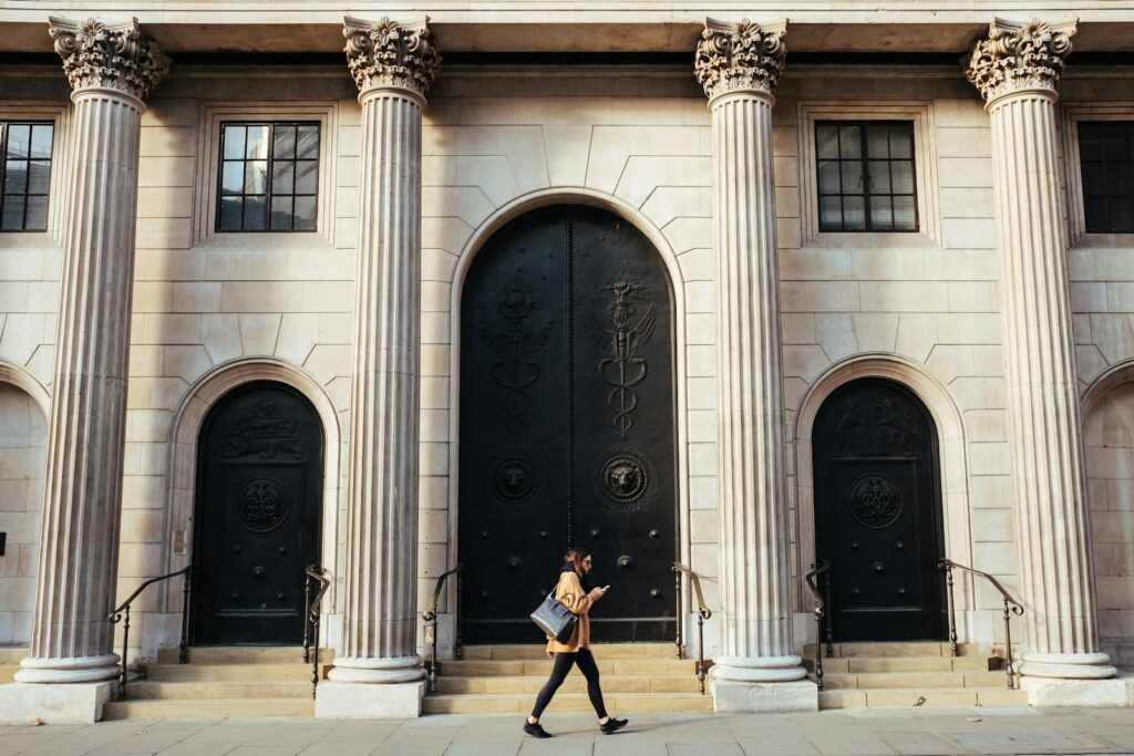 woman walking in-front of white building with ionic pillars